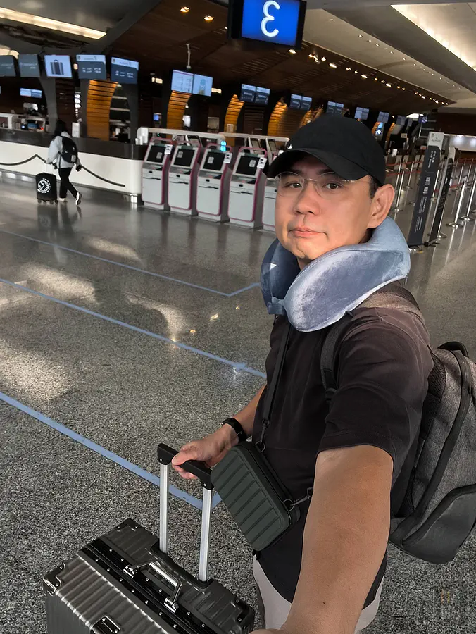 翰斯在機場使用 Travel Blue 頸枕與斜背包