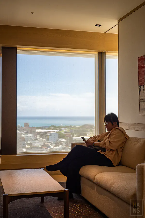 Kay 坐在尊貴環景溫泉套房的沙發上,窗外是太平洋海景