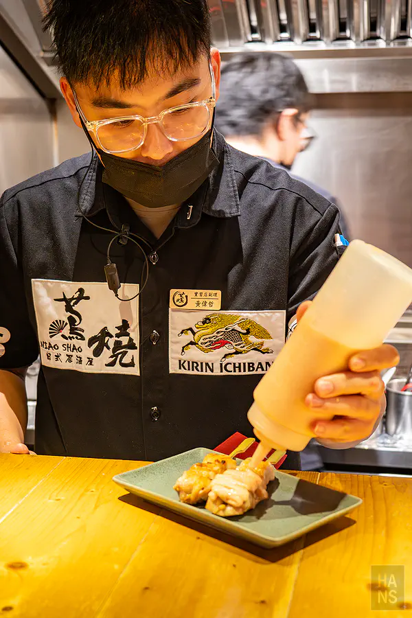 師傅在雞腿肉串上擠上厚厚的明太子醬