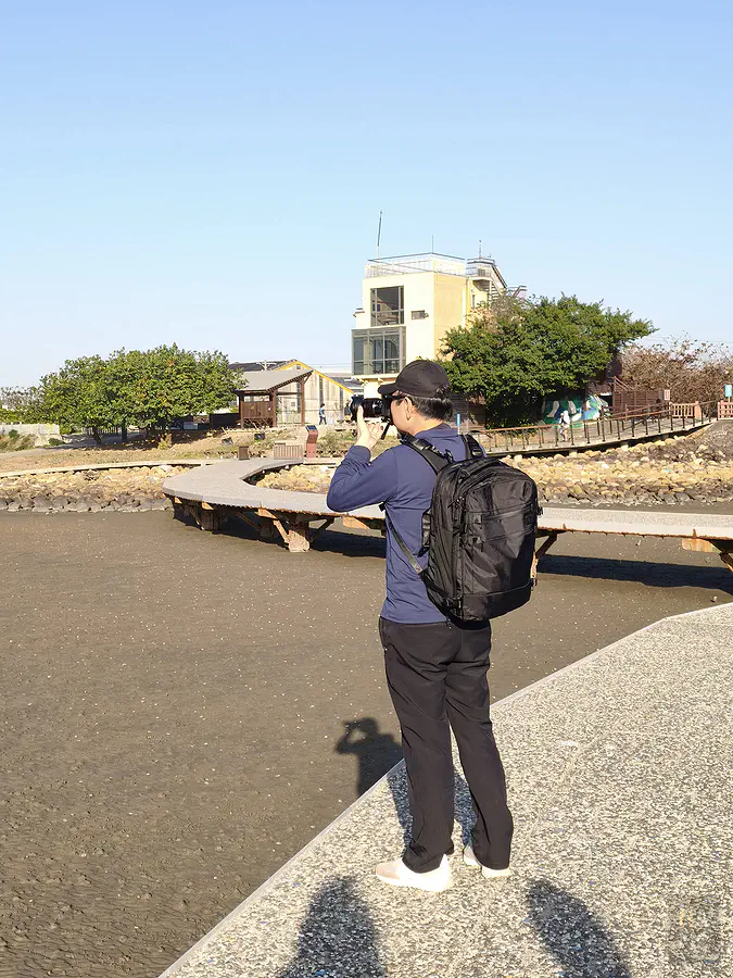 翰斯在海邊木棧道揹著包包實際拍攝，雙手解放的自由感