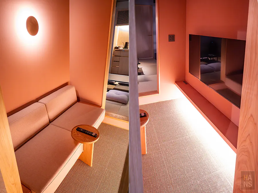 浦田別邸一樓溫暖橘紅色調的視聽休憩區與舒適布質沙發