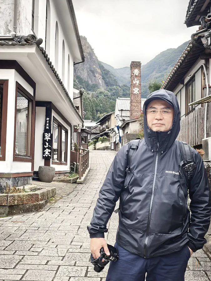 在寒冷空氣中於大川內山青山窯煙囪前包緊緊的旅遊紀念照