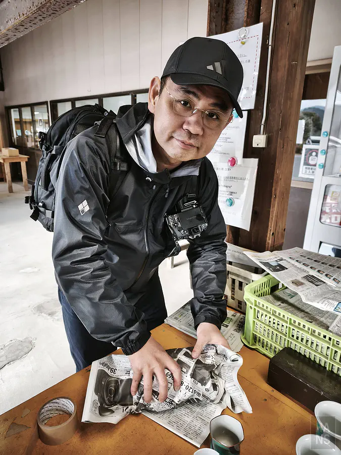 尋寶結束後使用現場報紙仔細打包瓷器的翰斯