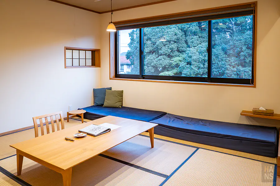 客房內大面採光窗戶與日式矮桌座墊