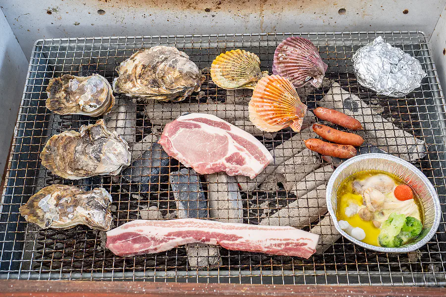 將豐富的海鮮與肉類食材鋪滿海道丸炭火烤網