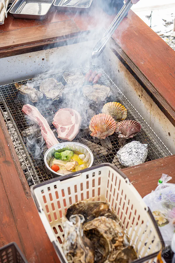炭火烤爐上冒著陣陣香氣的現烤海產與肉品