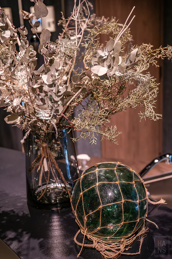 大廳角落充滿自然氣息的乾燥花藝與早期漁民使用的復古綠色玻璃浮球擺設