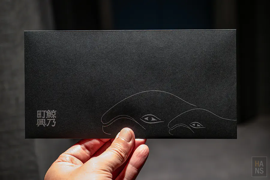 極具質感的極致黑房卡封套壓印著鯨乃町興字樣與優雅的鯨魚圖騰設計