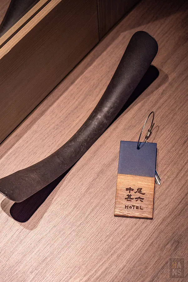 質感木作鑰匙圈與深色長型鞋拔刻有中尾甚六HOTEL專屬字樣