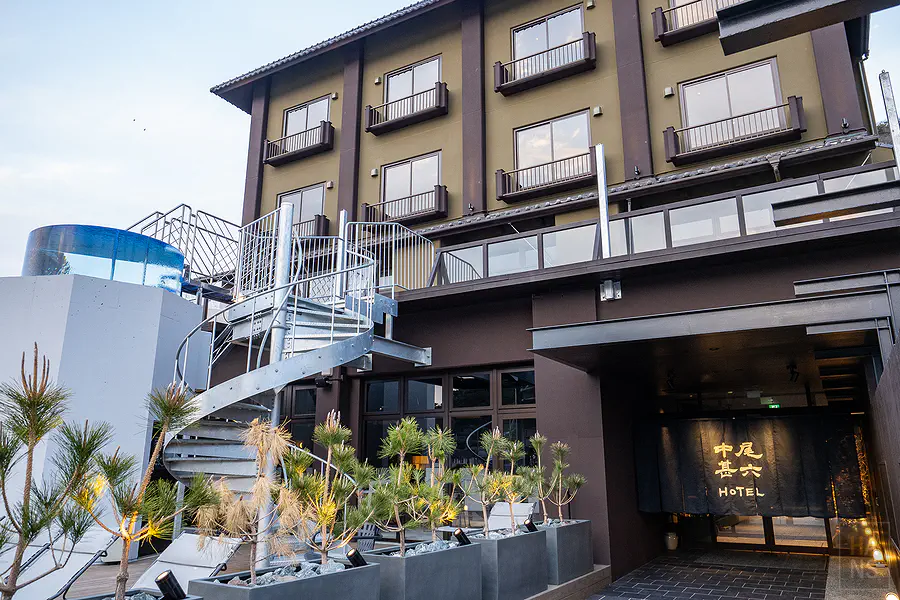 佐賀呼子住宿中尾甚六HOTEL本館深色質感外觀與極具現代感的金屬旋轉樓梯設計