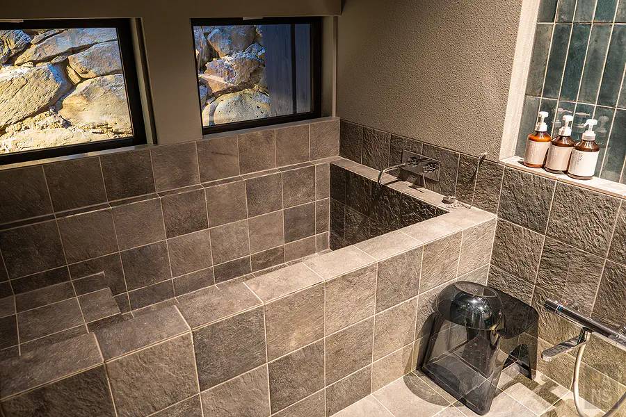 採用沉穩灰色石材打造的質感浴室與舒適的泡澡空間