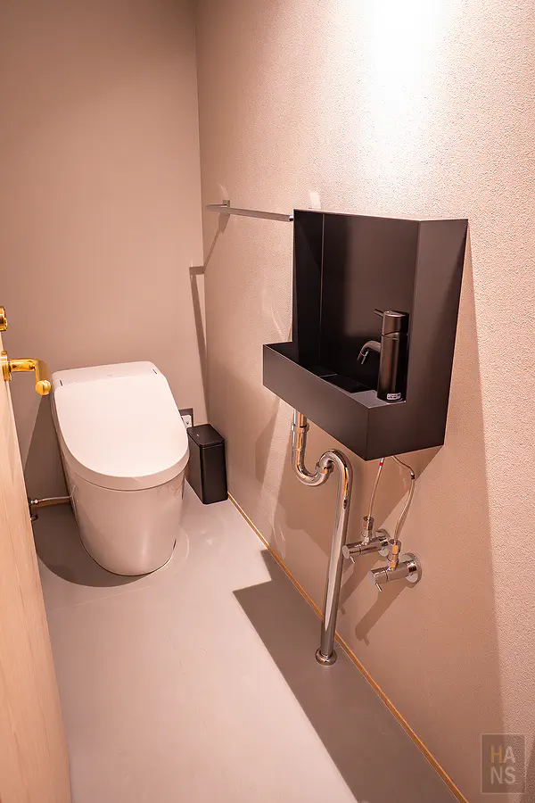 獨立分開的質感廁所空間配備免治馬桶與消光黑獨立洗手檯