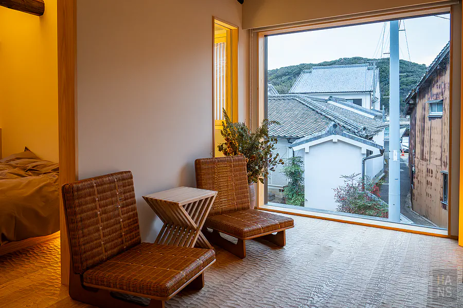 二樓大面積觀景窗與編織藤椅可俯瞰呼子町古民家街道與遠方山巒