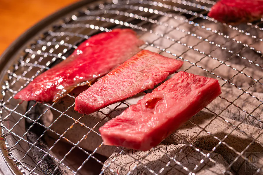 將粉嫩的佐賀牛肉片放上炭火烤網