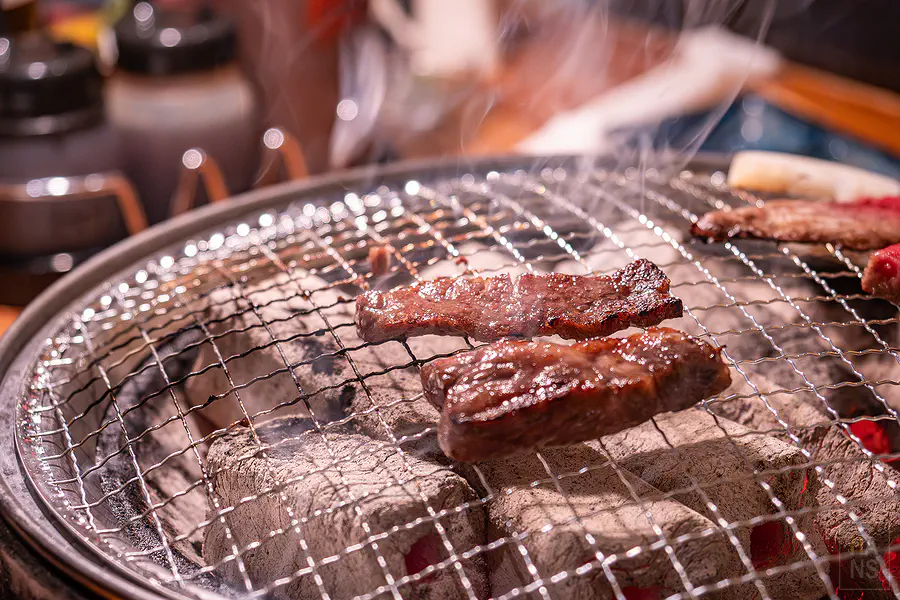 炭火烤網上香氣四溢的微焦佐賀牛肉片