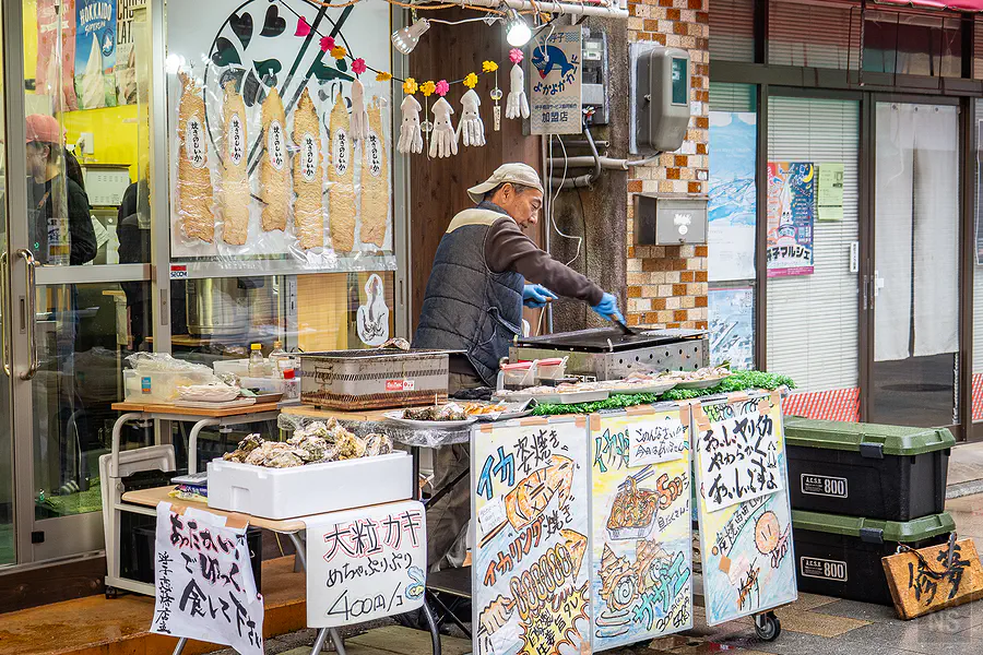 遊客在呼子朝市攤位前等待現烤的美味烏賊串燒