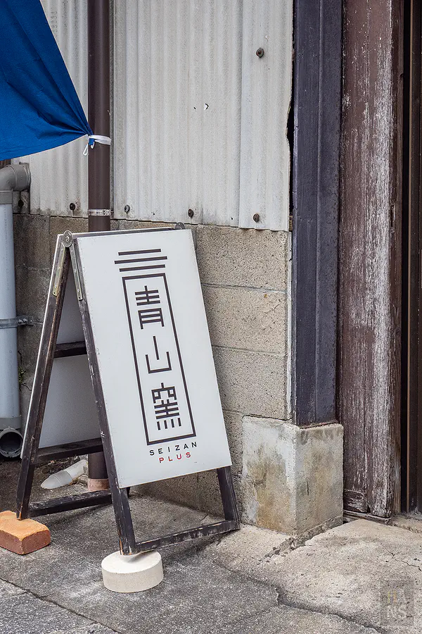 青山窯充滿現代設計感的窯場立牌與充滿歷史感的建築對比