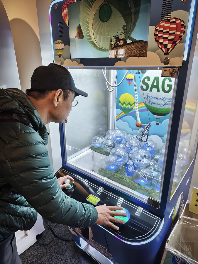 翰斯開心地跟扭蛋機合照
