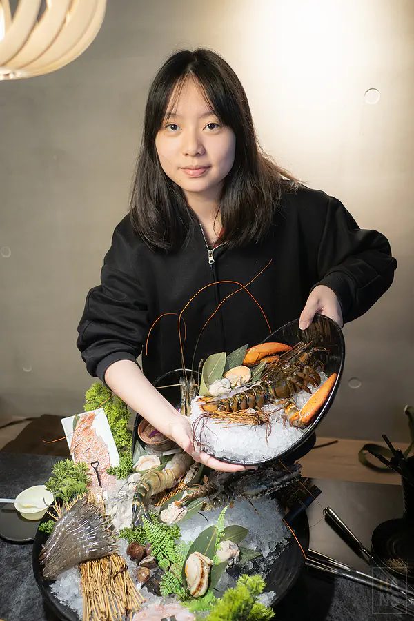 Zoe捧著巨大的龍蝦海鮮拼盤展現驚人比例