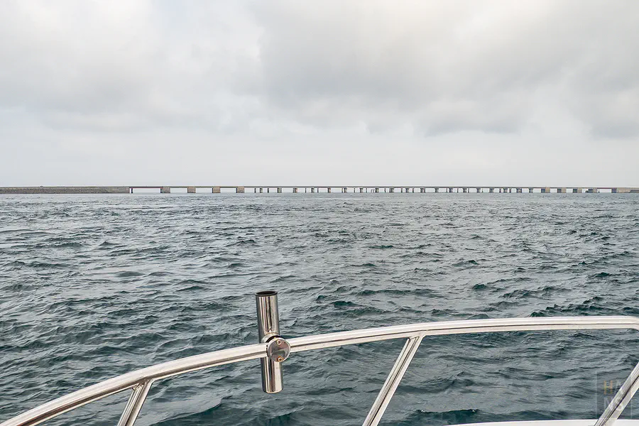 遊艇乘風破浪準備穿過澎湖跨海大橋橋墩下的動感畫面