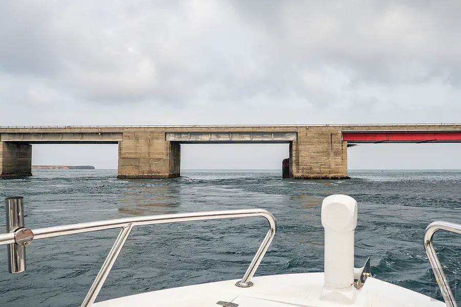 遊艇過橋後回望澎湖跨海大橋在陽光與湛藍海面上的雄偉身影