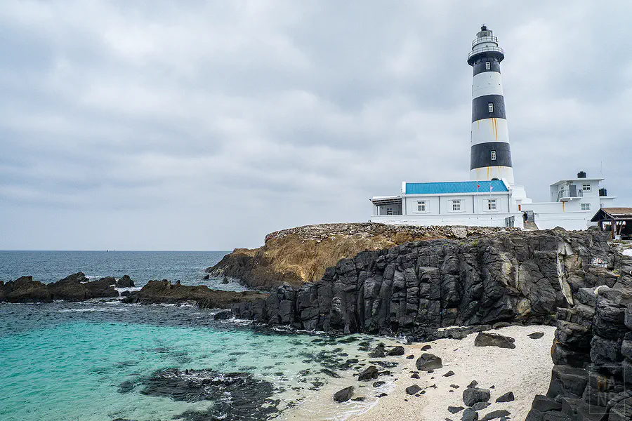 近距離細看目斗嶼燈塔黑白條紋塔身細節與厚實的玄武岩基座