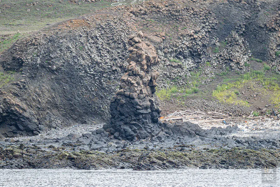 遊艇緩緩靠近鐵砧嶼高大雄偉的天然玄武岩海蝕洞景觀