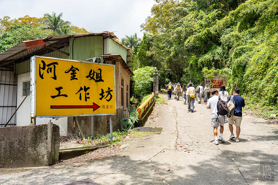 阿金姐工作坊黃色顯眼指標與走入園區的遊客
