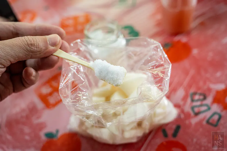 將適量的砂糖加入裝有蘿蔔塊的袋子中